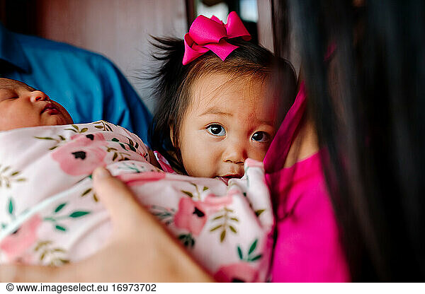 Sweet asian girl with big brown eyes meets newborn sister