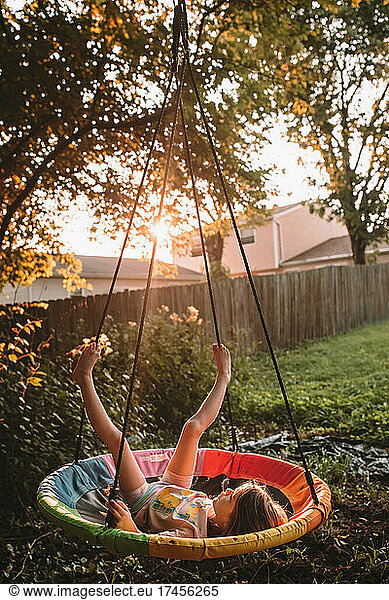 Swinging on her tree swing at sunset