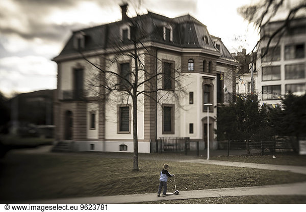 Switzerland  Basel  boy with scooter in front of a house