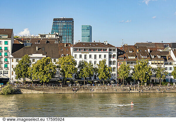 Switzerland  Basel-Stadt  Basel  Riverside promenade in summer with row of old town apartments in background