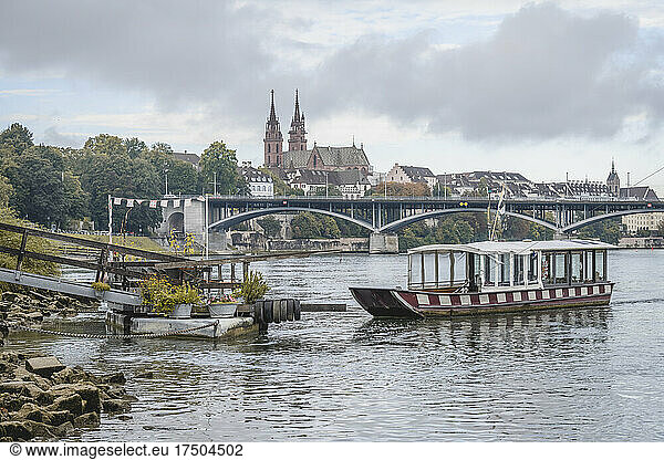 Switzerland  Basel-Stadt  Basel  Small ferry waiting on river Rhine canal with bridge and Basel Minster in background