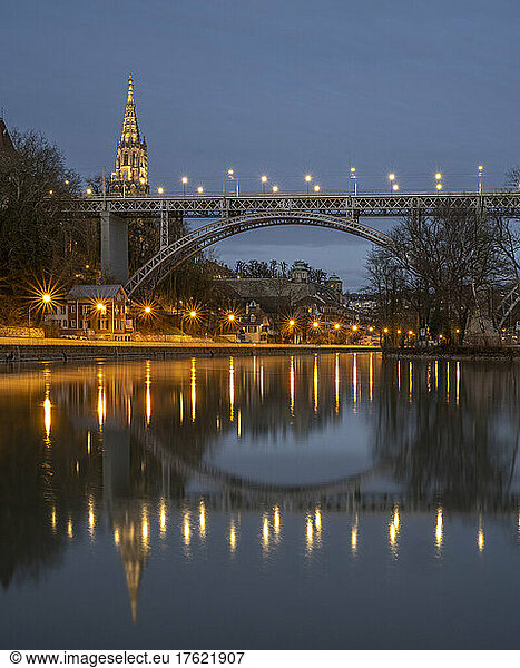 Switzerland  Canton of Bern  Bern  Aare river canal and Kirchenfeld Bridge at dusk with bell tower of Cathedral of Bern in background