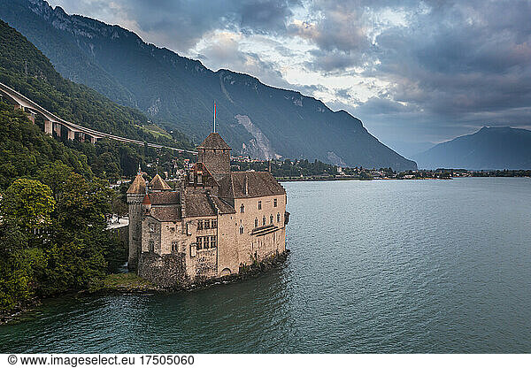Switzerland  Canton of Vaud  Veytaux  Aerial view of Lake Geneva and Chillon Castle at dusk
