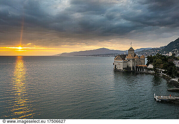 Switzerland  Canton of Vaud  Veytaux  Aerial view of Lake Geneva at cloudy sunset with Chillon Castle in background