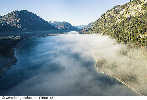 Sylvensteinsee lake amidst mountains in foggy weather  Bad Tolz  Bavaria  Germany