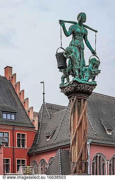 Szene mit einer Wasser tragenden Frau am Raubrunnen in der historischen Altstadt von Freiburg im Breisgau  Baden-Württemberg  Deutschland.