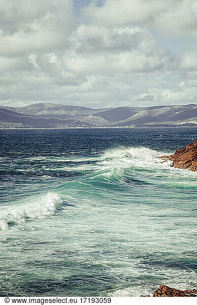 Türkisfarbene Wellen  die sich in einem Meer aus Felsen mit großer Kraft brechen