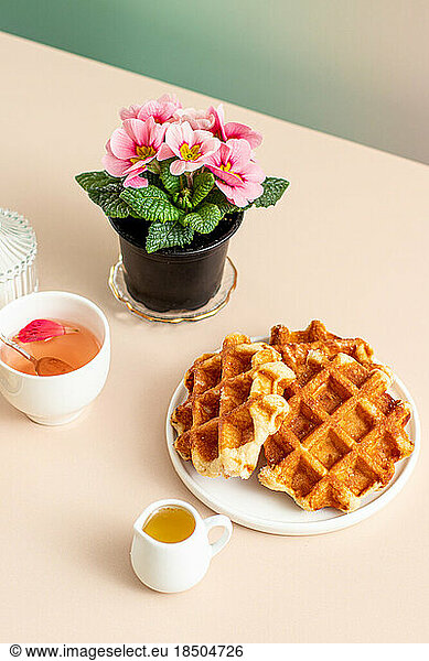 Table with Belgian waffles and honey