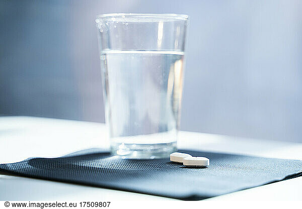 Tablets and water glass on napkin