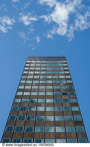 Tall office building stands alone under a sunny blue sky