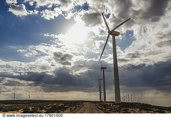Tall wind turbines at wind farm on sunny day