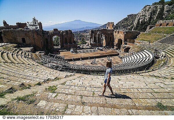 Taormina Griechisches Theater alias Teatro Greco Tourist am Amphitheater mit Vulkan Ätna im Hintergrund Sizilien Italien Europa. Dies ist ein Foto von einem Touristen am Teatro Greco alias Taormina Griechisches Theater oder Amphitheater mit dem Vulkan Ätna im Hintergrund Sizilien Italien Europa.