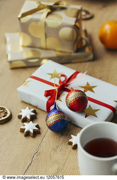 Tasse Tee Zimtsterne und Weihnachtsgeschenke im Hintergrund