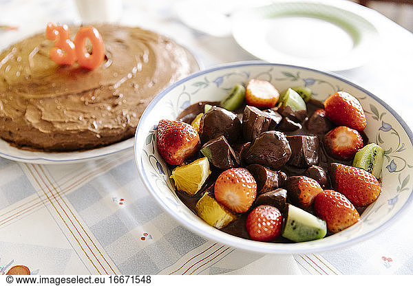 Tasty fruits and chocolate along a birthday cake for a 30th birthday