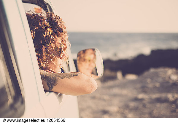 Tatooed woman looking out of a car
