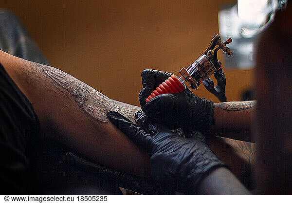 tatto artist tattooing a samurai to a white man