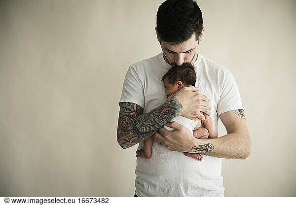 Tattooed Millennial Dad Kisses Top of Newborn Son's Head