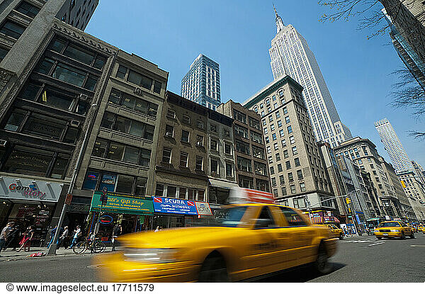 Taxi Passing In Front Of The Empire State Building  Manhattan  New York  Usa