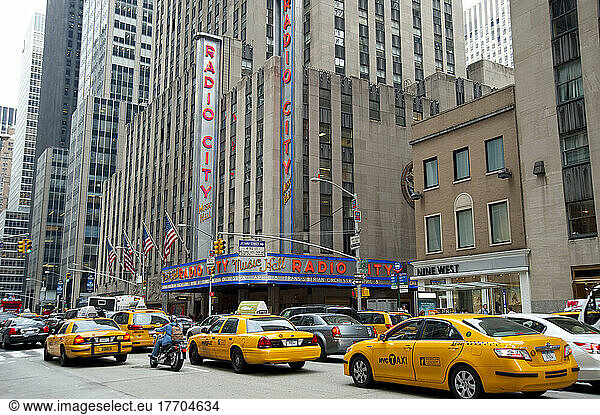 Taxis Passing By Radio City Music Hall  Famous Entertainment Venue Located In Rockefeller Center  Midtown Manhattan  New York  Usa