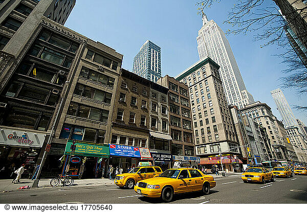 Taxis Passing In Front Of The Empire State Building  Manhattan  New York  Usa
