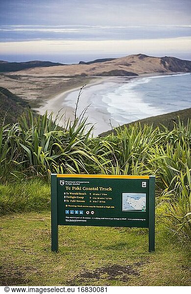 Te Paki Coastal Track Schild  mit Te Werahi Beach dahinter  Cape Reinga  Neuseeland