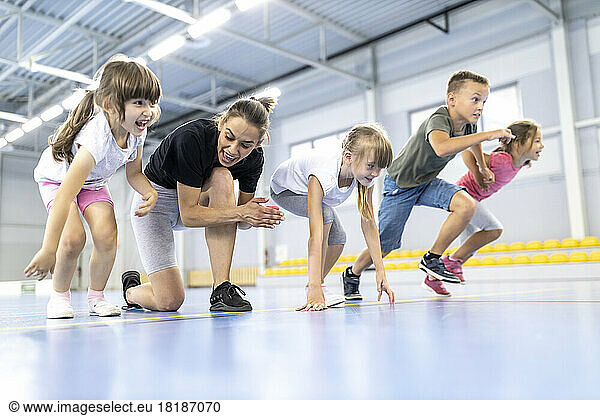 Teacher cheering students at race in school sports court