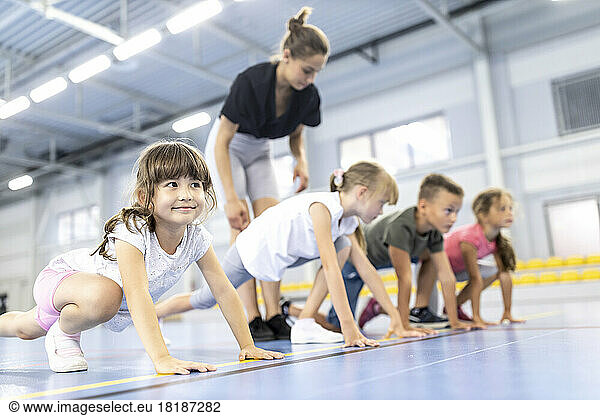 Teacher lining students at starting position in school sports court