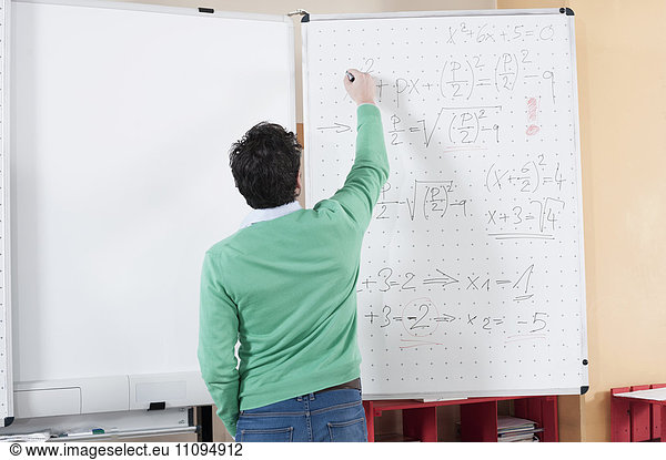 Teacher teaching mathematics on whiteboard  Bavaria  Germany