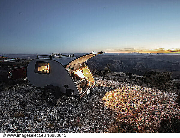 teardrop RV camper at campsite at twighlight with lights on  Utah
