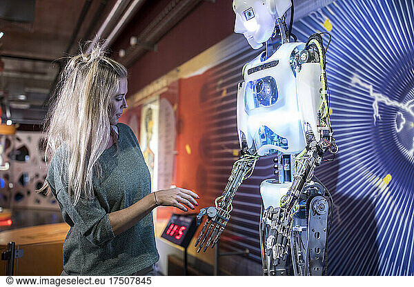 Technician doing handshake with human robot at workshop