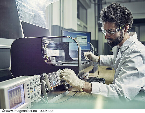 Technician operating 3d printing machine in laboratory