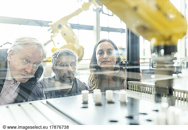 Technicians testing and observing new industrial robot
