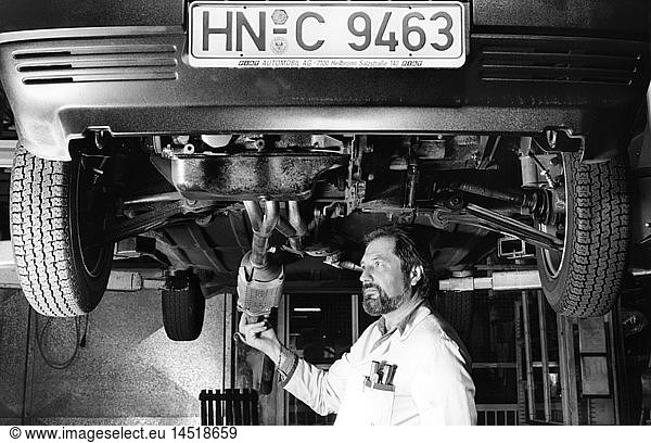 technics  workshops  garages  mechanic mounting a catalytic converter on a car  West Germany  circa 1980s