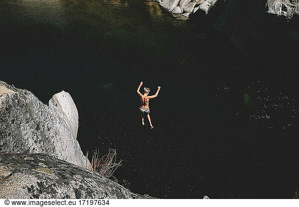 Teen Boy Leaps from High Cliff Into Dark Pool of Water