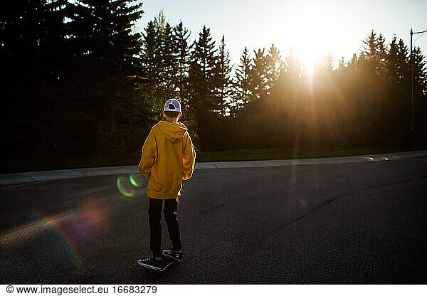Teen boy skateboarding on street
