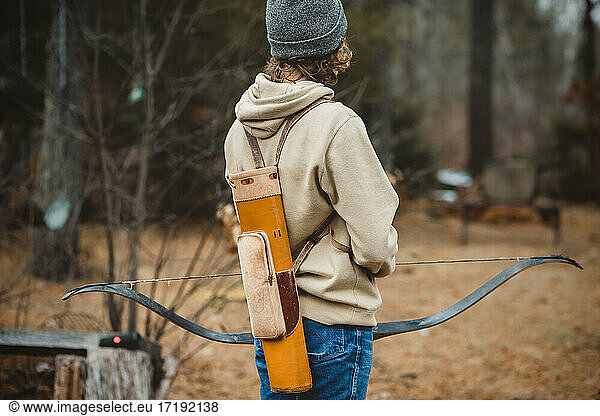 Teen boy with vintage quiver holding long bow in Wisconsin
