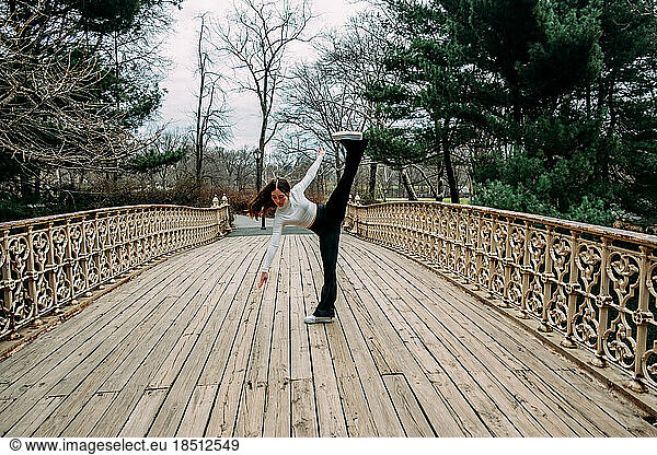 Teen girl dancing on bridge outside