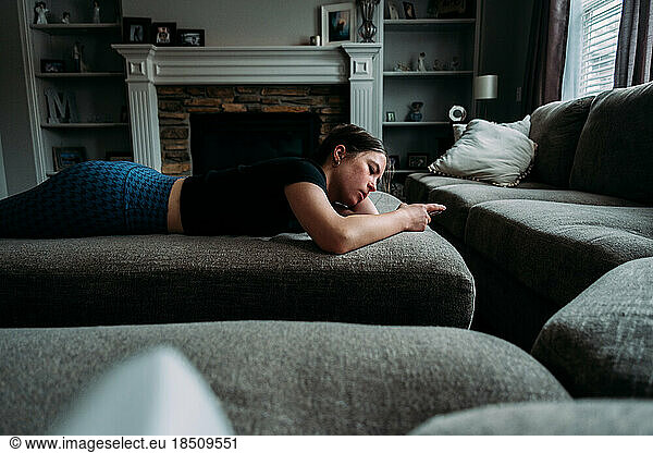 Teen girl laying on couch looking at phone