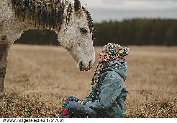 Teen girl looking into eyes of her horse
