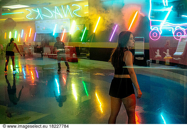 Teen girl roller skating at a trendy roller rink