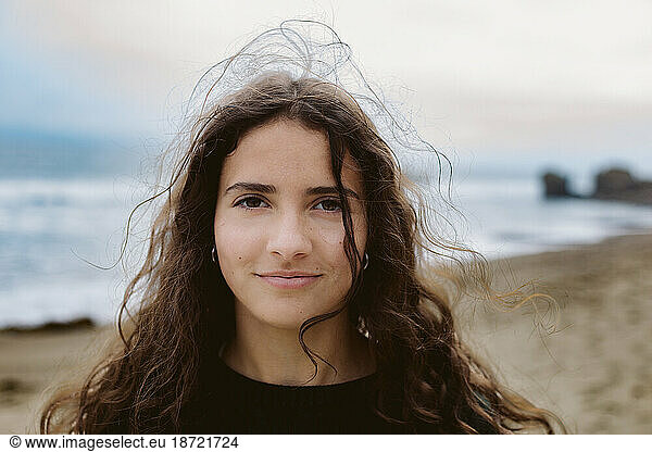 Teen Girl Smile As Wind Picks Up Her Hair At The Beach