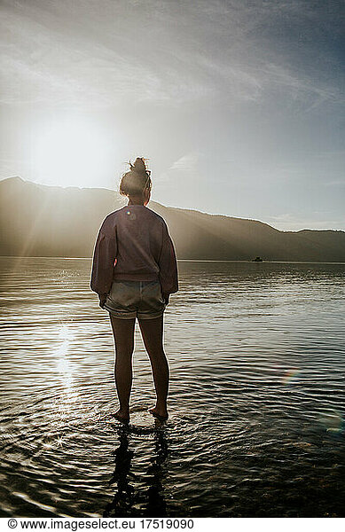 Teen girl standing on rock in lake
