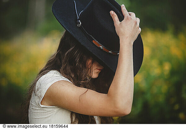 Teen girl tipping cowboy hat