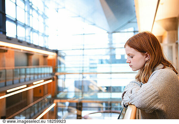 Teen girl with red hair at an urban library.
