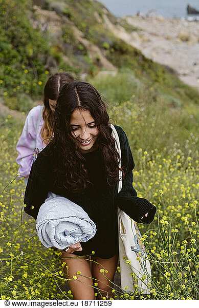 Teen Girls Walk Up A Wildflower Trail Away From Beach