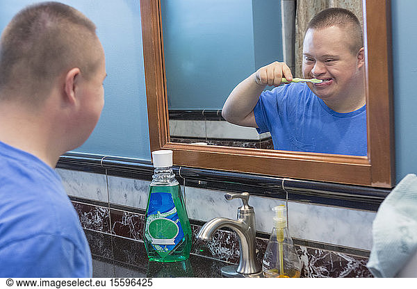 Teen with Down Syndrome brushing his teeth