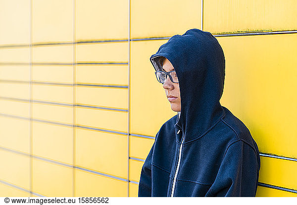 Teen with eyeglasses in a yellow background