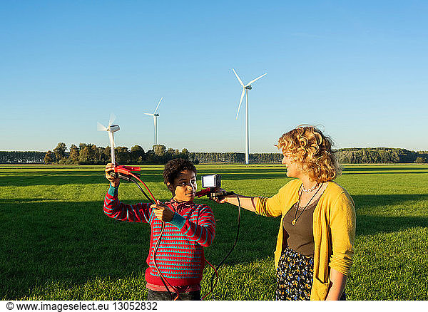 Teenage boy and girl experimenting with sustainable energy by wind turbines  Netherlands