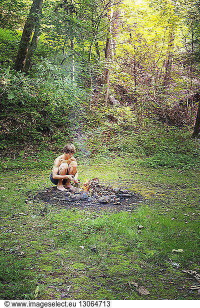 Teenage boy camping in forest