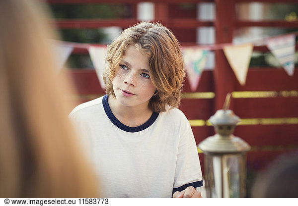 Teenage boy looking away in back yard